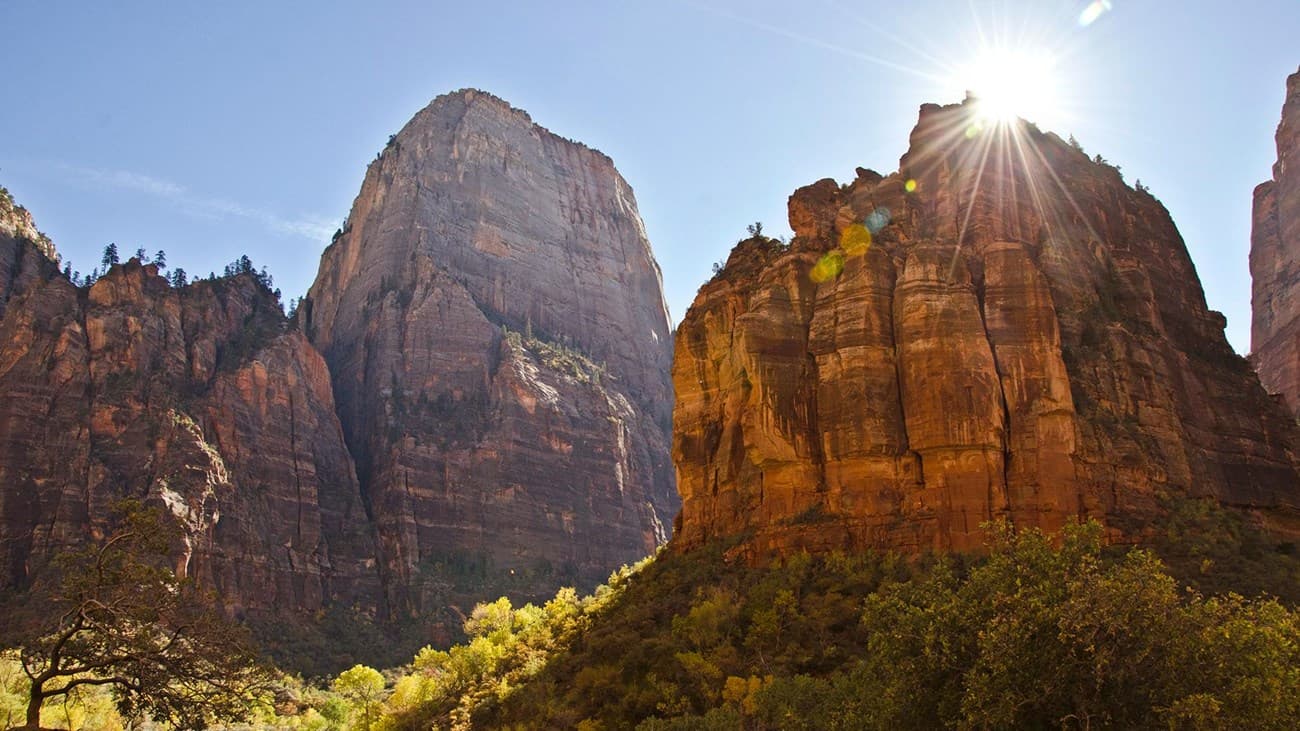 Sunshine behind red sandstone cliff at Zion National Park