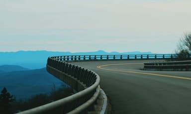 A turn in the Blue Ridge Parkway with mountains in the background