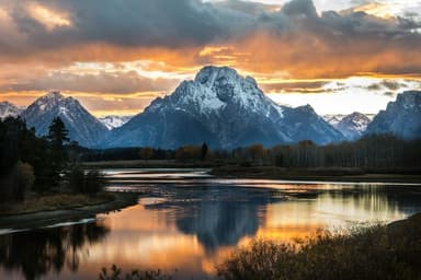 Mountains of Grand Teton reflecting in the water at sunset at Oxbow Bend
